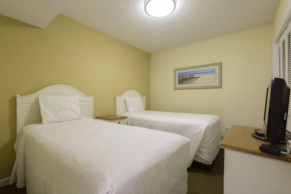 The inviting guest room with twin beds offers comfortable accommodations for families or friends traveling together.