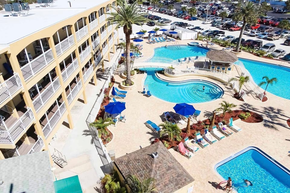 Take in the panoramic view of the sparkling pool area and lush amenities from above, basking in the Florida sun.