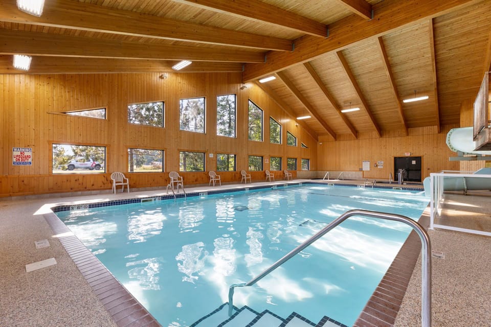Enjoy a refreshing swim in the inviting indoor pool surrounded by warm wooden walls and natural light.