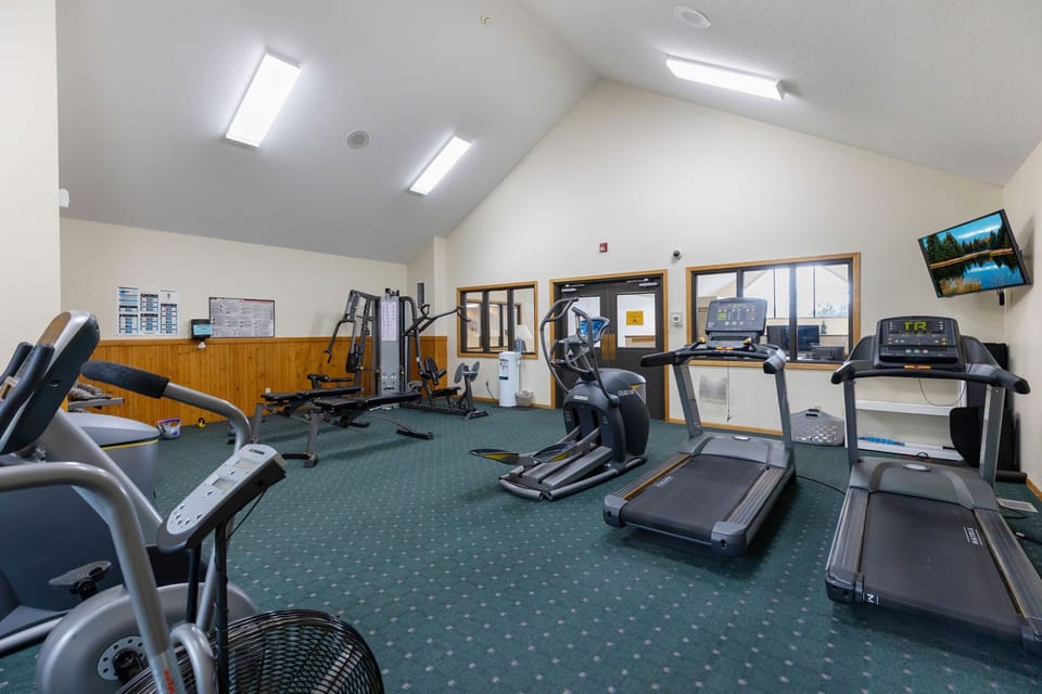 Fitness room equipped with treadmills, bikes, and natural light for a complete workout.