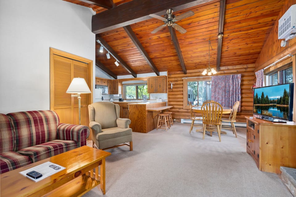 Open-concept living room with cozy seating and cabin décor, ideal for family relaxation.