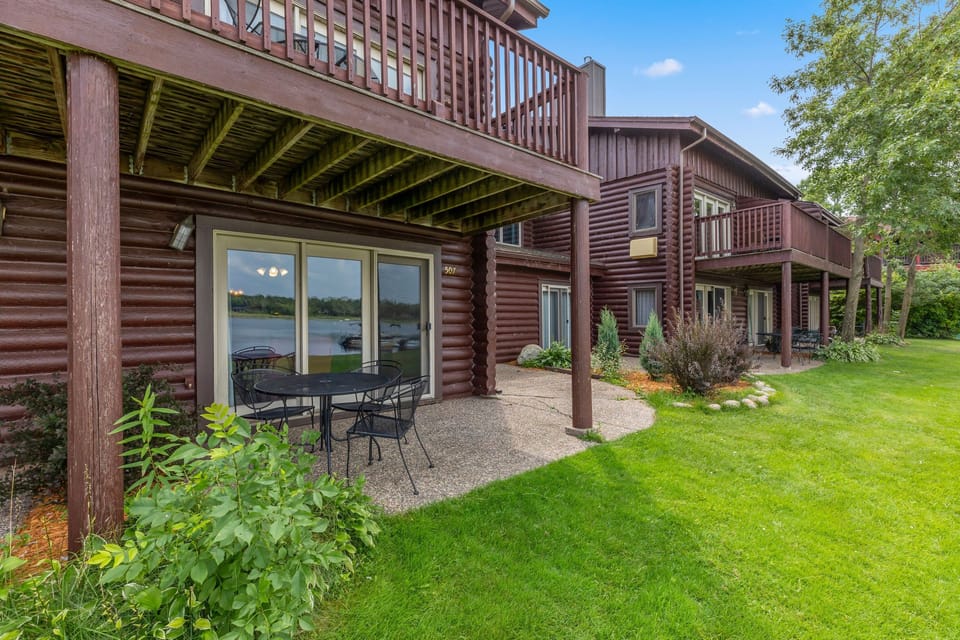 Ground-level patio with outdoor seating overlooking the lawn.
