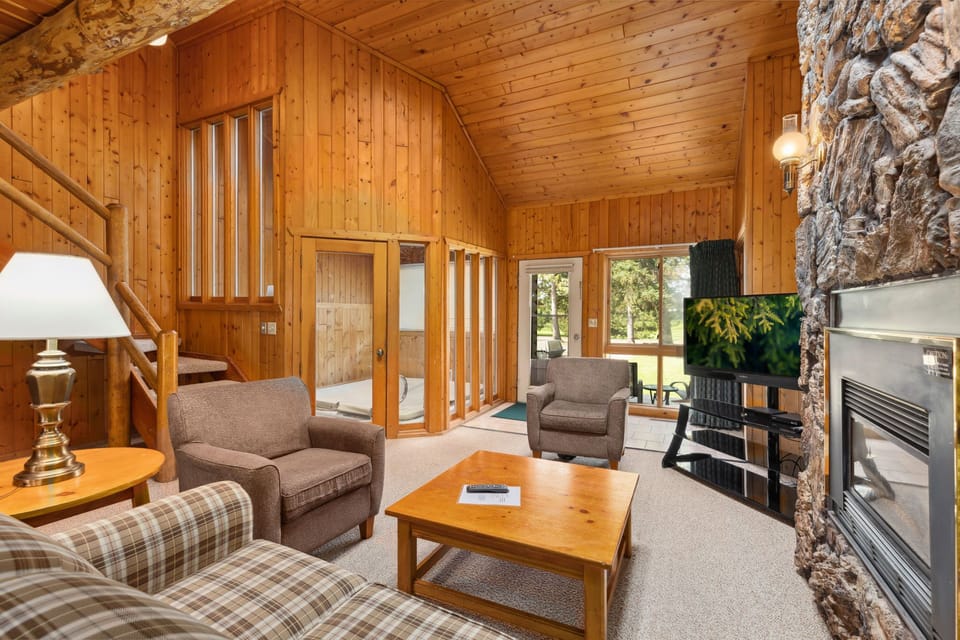Welcoming sitting area with natural wood walls and fireplace warmth.
