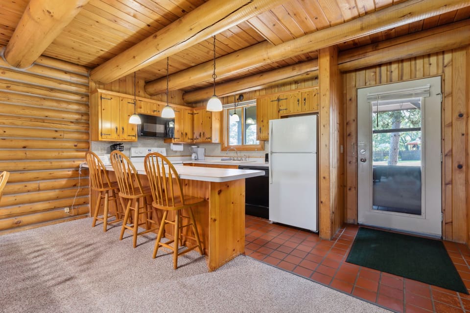 Rustic kitchen with warm wood cabinetry, breakfast bar, and modern appliances.