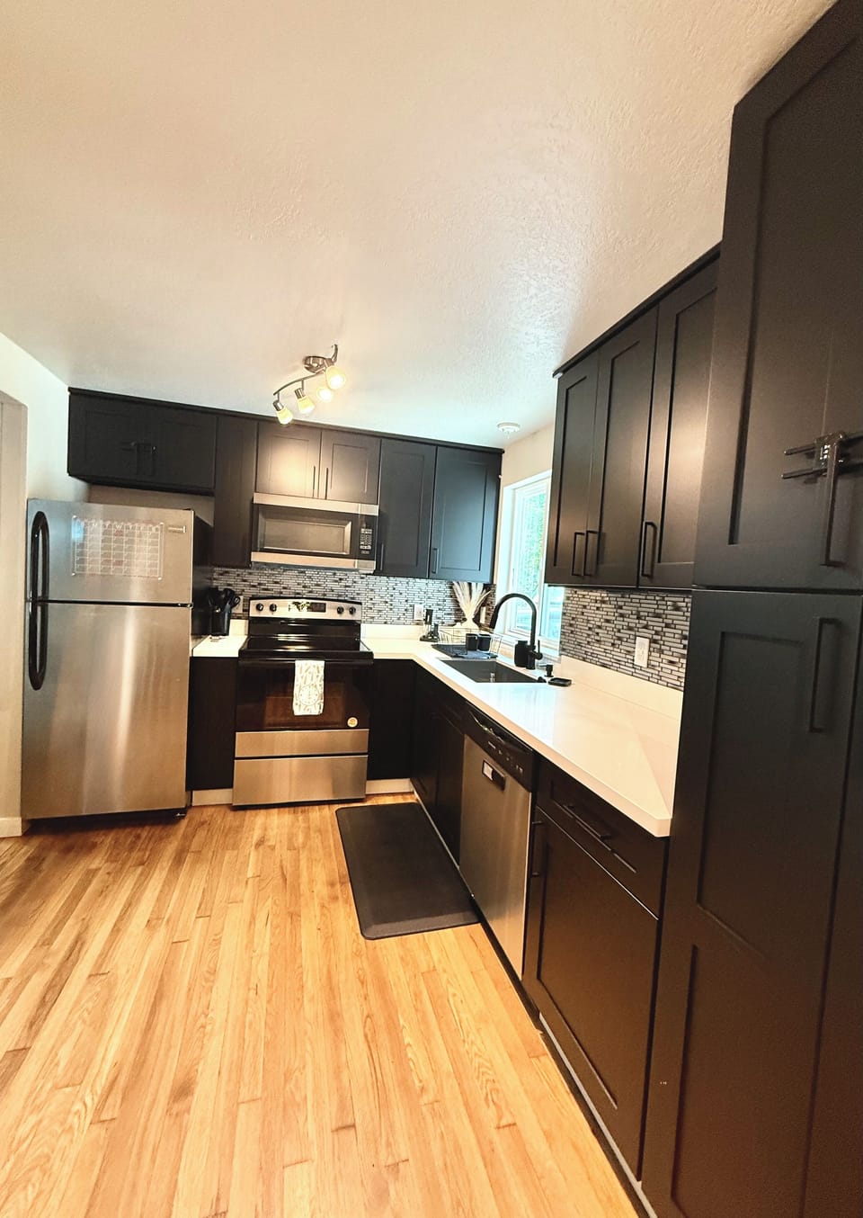 The modern kitchen is equipped with stainless steel appliances, sleek cabinetry.