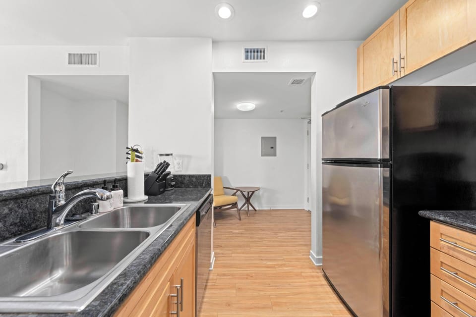 Kitchen Sink & Entry - kitchen with stainless steel fridge and full sink setup