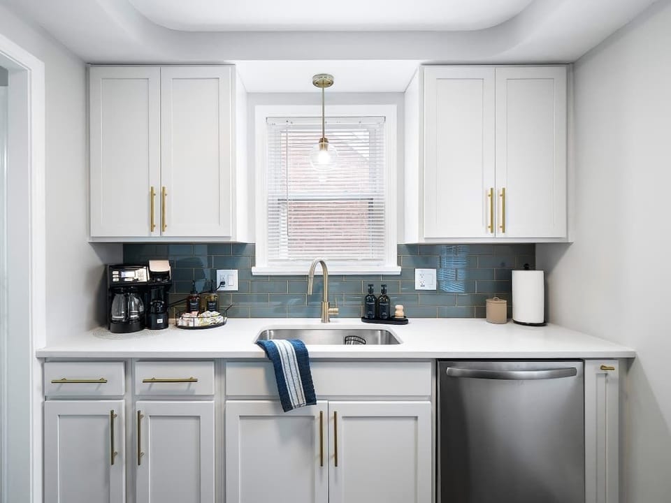 Start your day in this sleek kitchenette ☕ featuring a coffee station, modern appliances, and elegant brass accents. Bright, clean, and fully equipped—perfect for quick meals or morning brews! 