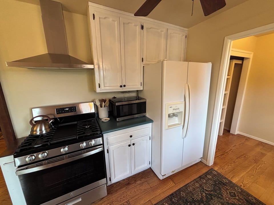 Kitchen with oven and stove top, microwave, refrigerator, coffee maker and more