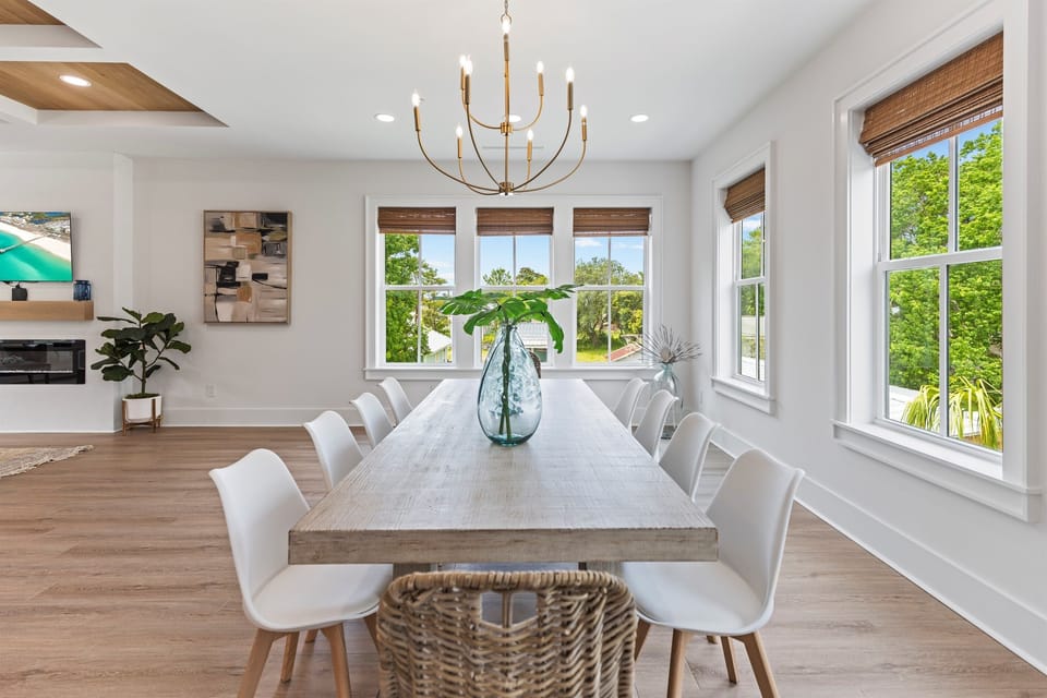 Gather around this beautiful dining table where natural light streams through expansive windows, creating the perfect setting for memorable meals with loved ones.