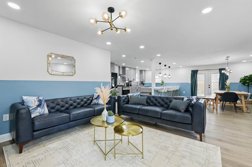 This upscale living room will transport you to a world of comfort and luxury with its decadent blue couches, decorative pillows, and sophisticated décor!