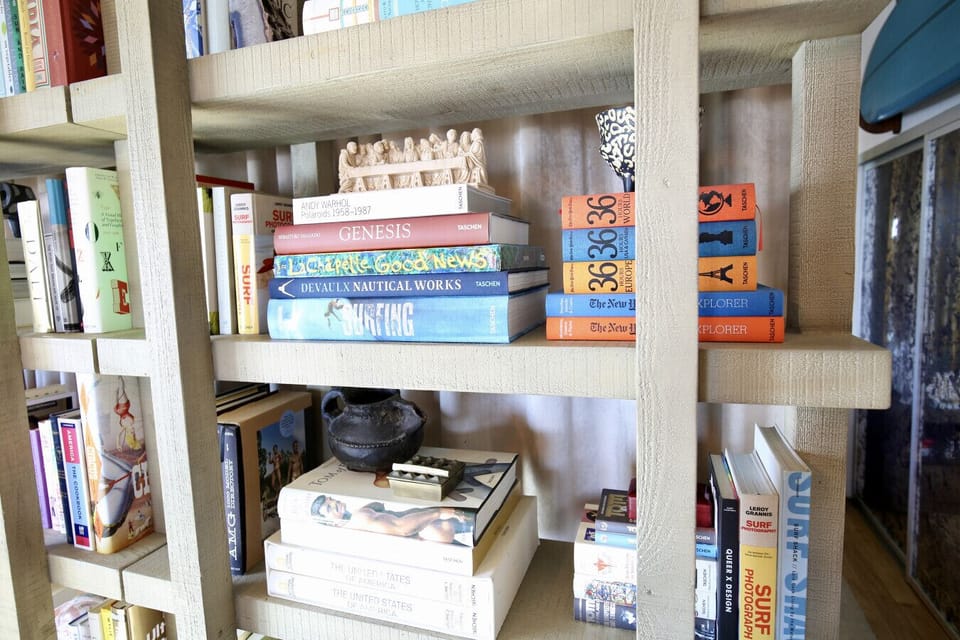 A cozy corner for slow-paced days — unwind with a good book from our thoughtfully stocked shelf and let time slow down.