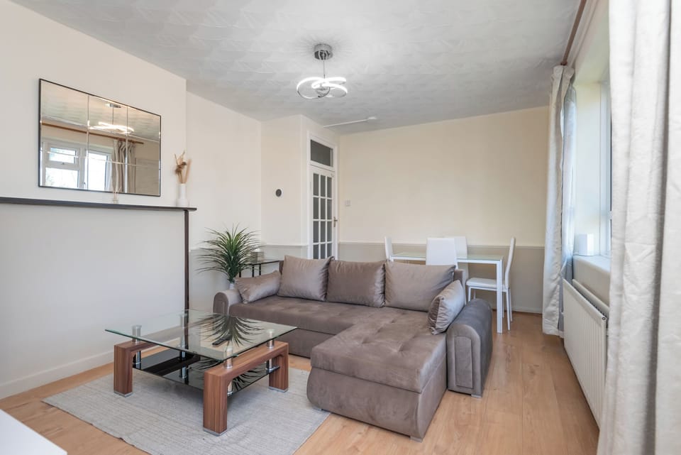 Lounge with plush sofa, glass coffee table, and airy curved ceiling.