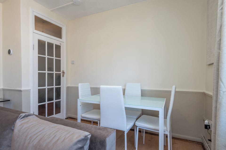 Bright dining space with glass-top table & four chairs — perfect for meals/work.