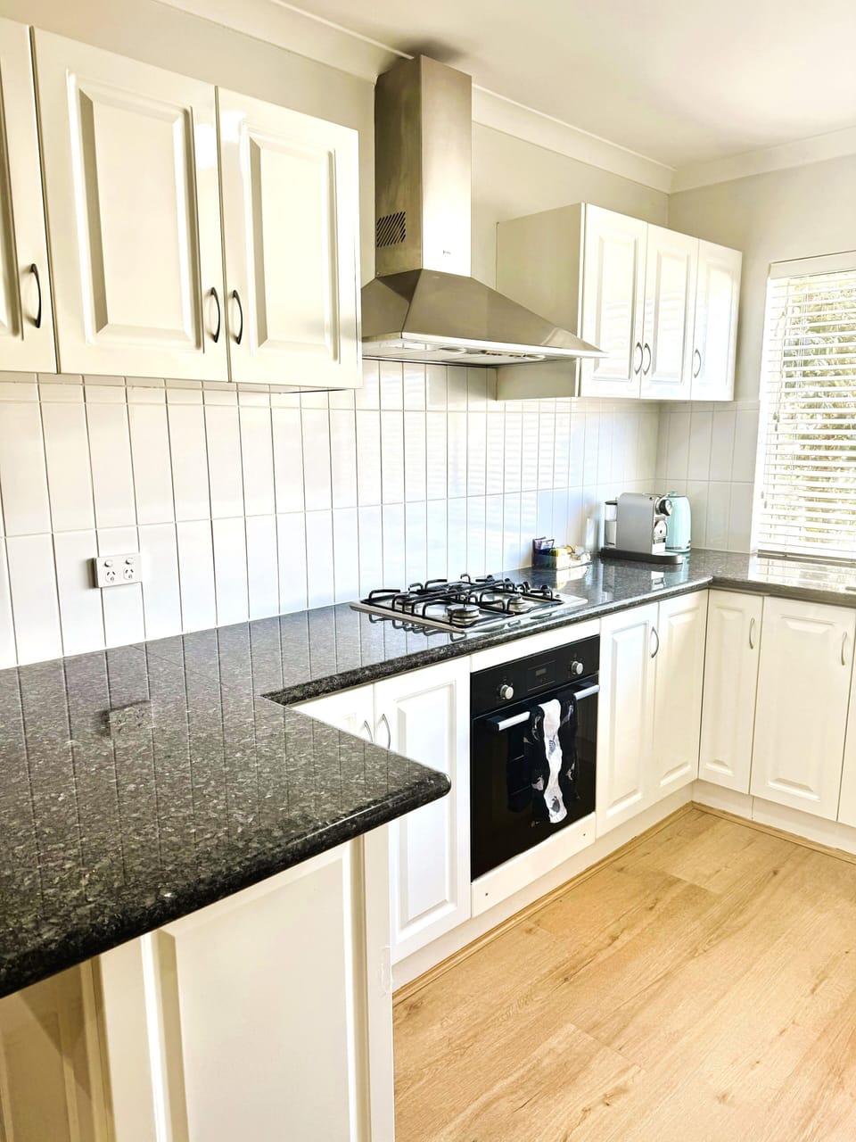 Whip up delicious meals in this fully equipped kitchen, featuring a modern stove, oven, and range hood.
