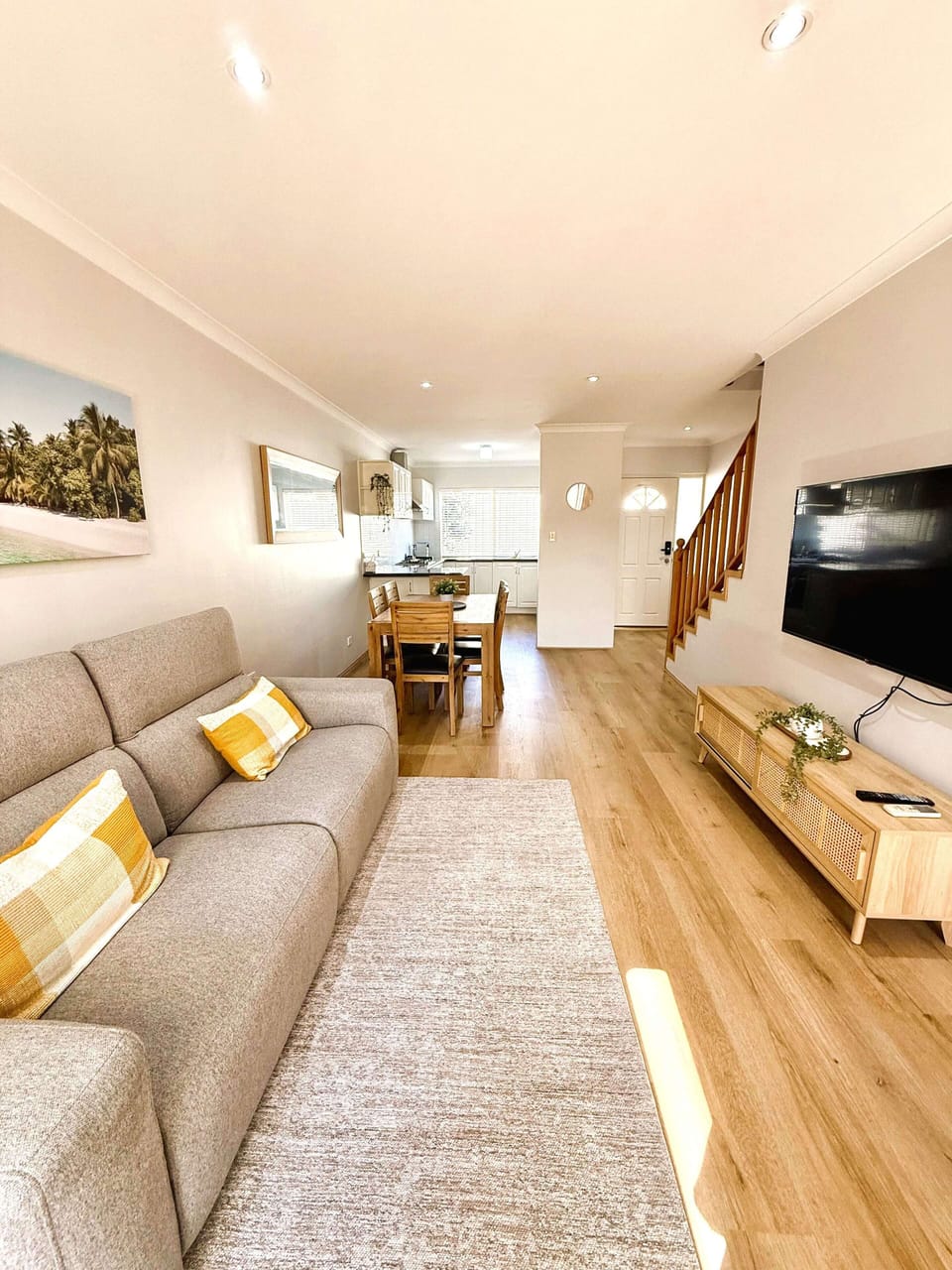 Escape to comfort in this spacious living and dining area, featuring a cozy sofa, television, and a wooden dining table that seats 4. Enjoy the convenience of air conditioning and seamless access to the well-appointed kitchen.