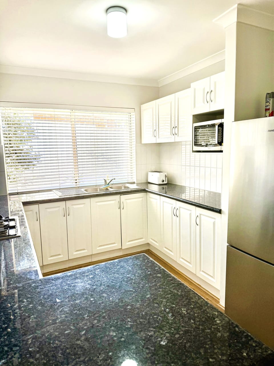 Whip up your favorite meals in this well-appointed kitchen, featuring ample cabinets, a toaster, microwave, and refrigerator for your convenience.