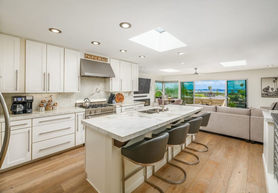 Cook, gather, and entertain in style—this sleek kitchen features stainless steel appliances, spacious island seating and a breezy Pacific Beach vibe.