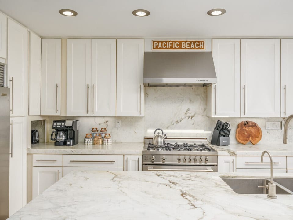 Cook, gather, and entertain in style—this sleek kitchen features stainless steel appliances, spacious island seating and a breezy Pacific Beach vibe.