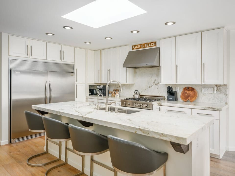 Cook, gather, and entertain in style—this sleek kitchen features stainless steel appliances, spacious island seating and a breezy Pacific Beach vibe.
