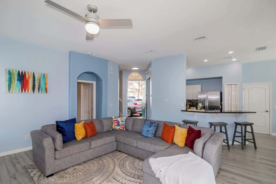 Open living space with TV, large sofa, and back yard access