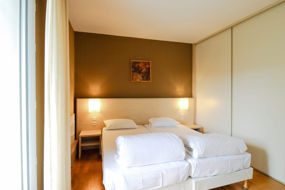 Unwind in a serene bedroom with soft lamps and crisp linens.
