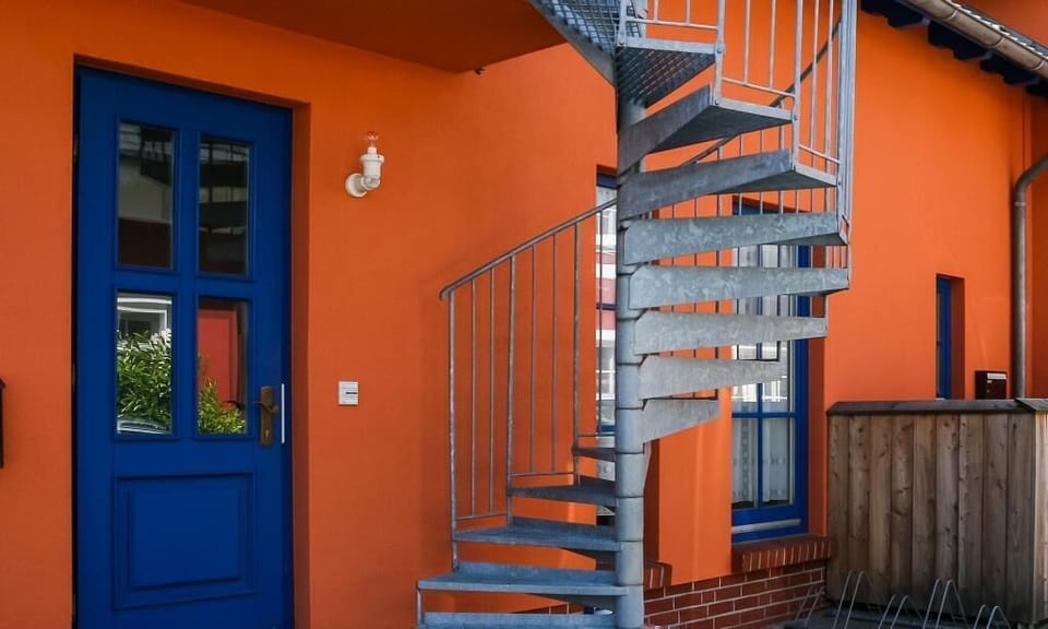 Exterior View with Blue Door and Spiral Staircase