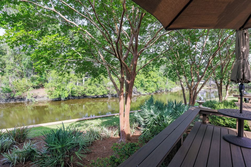 This serene outdoor space is designed for slow mornings and shaded afternoons, set along a tranquil lagoon framed by mature trees and lush landscaping.