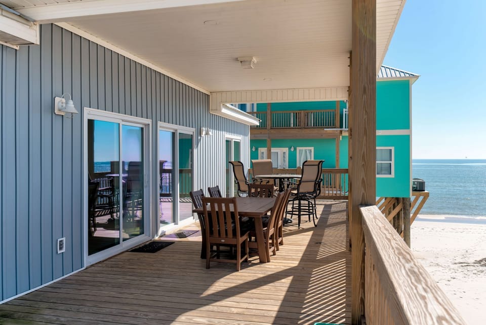 Your beachfront deck stretches along the water with dining tables perfect for morning coffee or sunset meals.