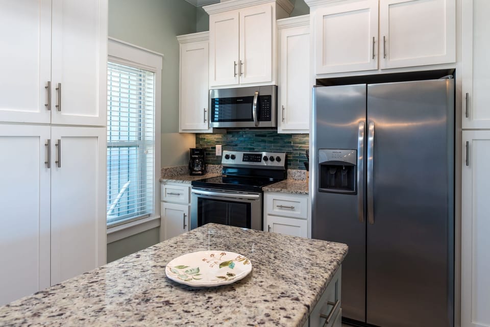 Your gourmet kitchen features granite countertops, stainless steel appliances, and crisp white cabinetry perfect for preparing memorable meals.