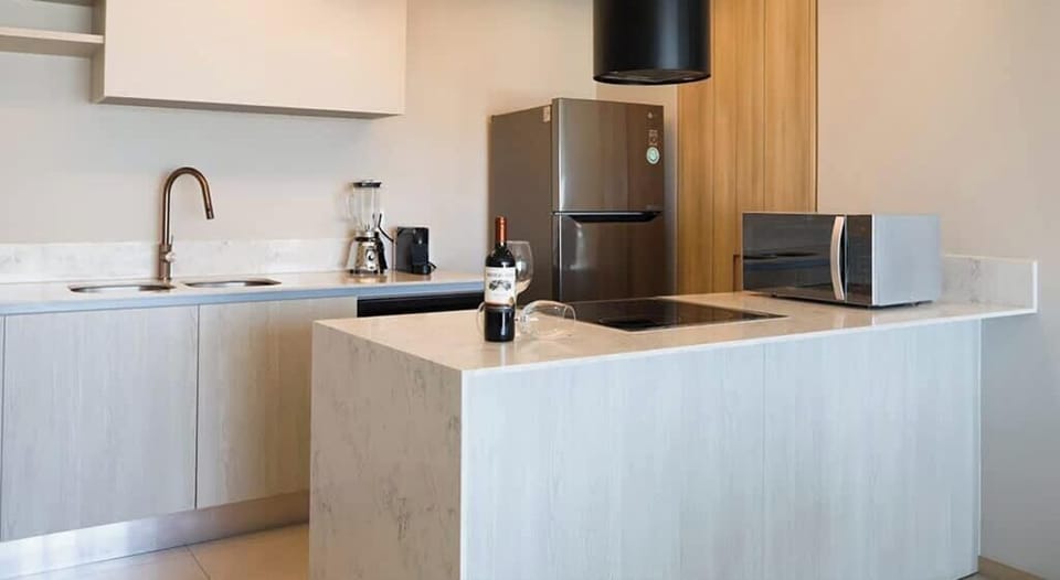 Modern kitchen w/ sleek counters, cooktop & stainless appliances