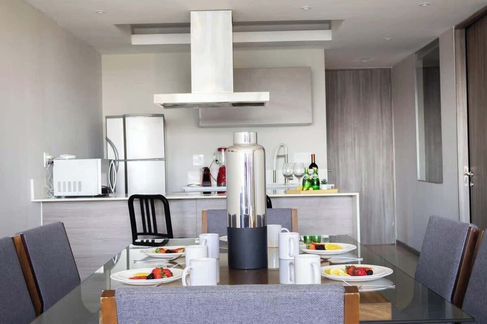 Dining area w/ table setting flowing into the modern open kitchen