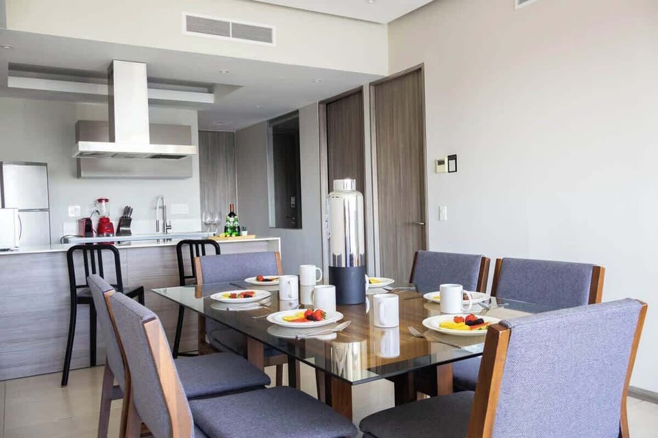 Dining table set for a shared meal beside the open kitchen