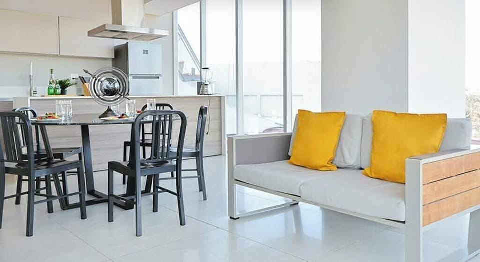 Open dining area w/ modern table & bench seating beside large windows