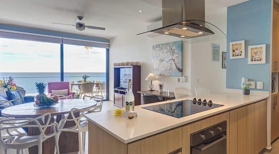 Modern kitchen w/ island seating, stainless fridge & open layout flowing toward the living area