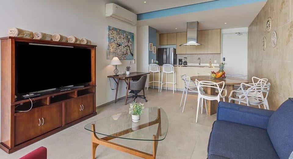 Open living room w/ sofa seating, TV & dining space nearby