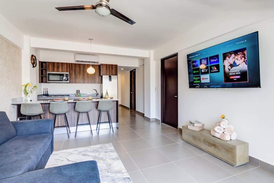 Lounge area w/ wall-mounted TV and breakfast bar seating just steps away