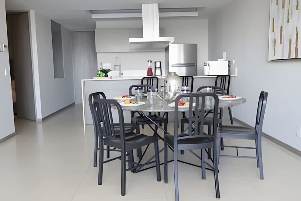 Dining table set for shared meals in a sleek open-concept space beside the kitchen