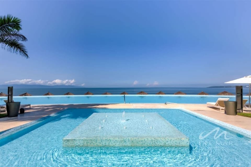 Shared rooftop-style pool overlooking the ocean, perfect for a refreshing swim at sunset