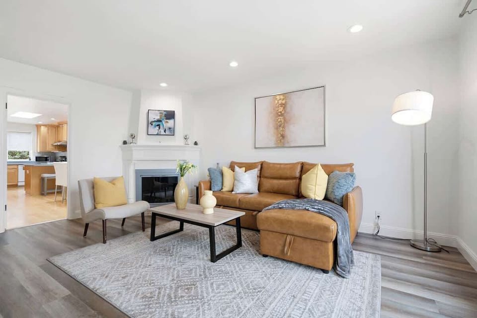 Cozy and spacious living room with a three-seat convertible sofa-bed, a fireplace, and a smart TV