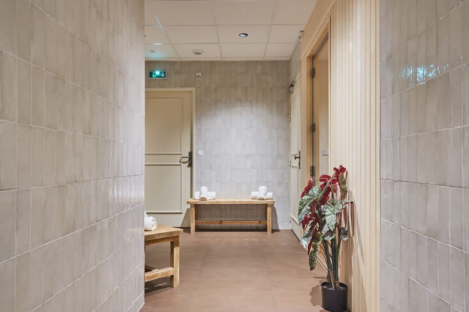 Tranquil hallway leading to spa areas, featuring soft lighting and stylish seating.