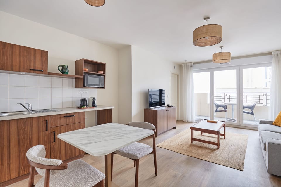 Open-plan layout with fully equipped kitchenette, dining area, and comfortable sofa—ideal for short or extended stays.