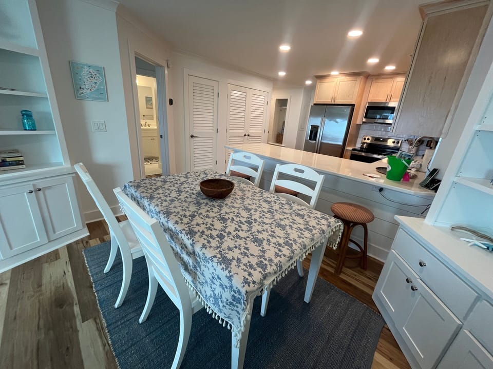 This bright dining area seamlessly connects to the living room, creating an open and inviting space for gathering after a day at the beach.