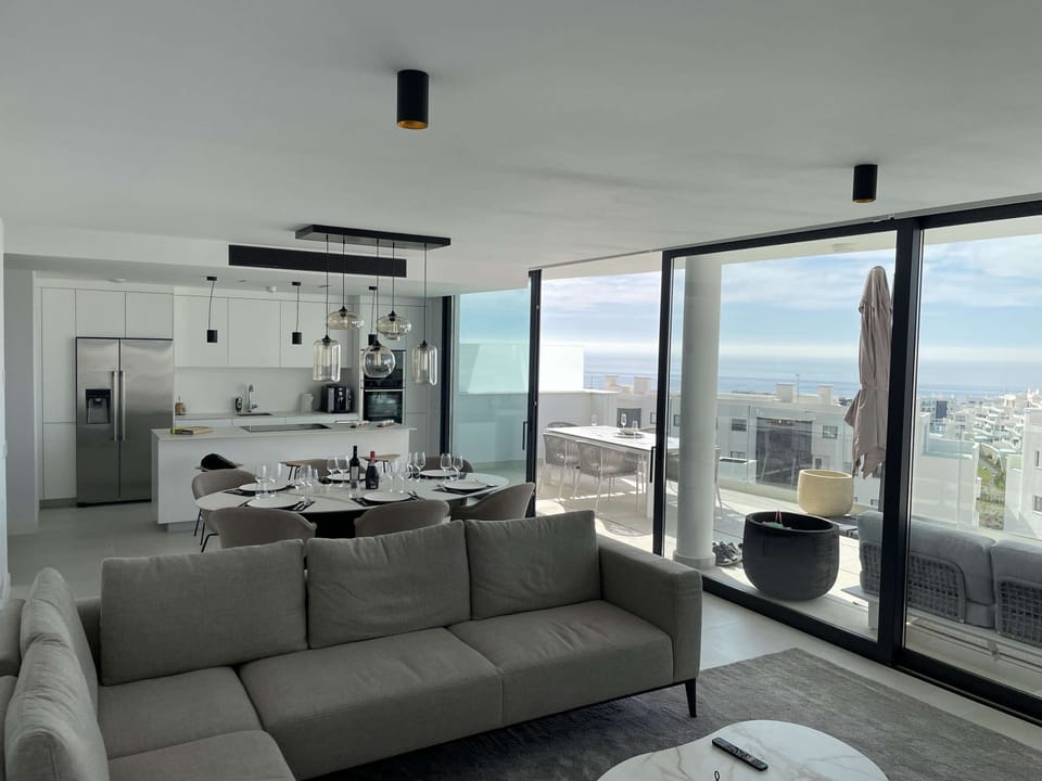 Modern living–dining area with large windows. 🛋️