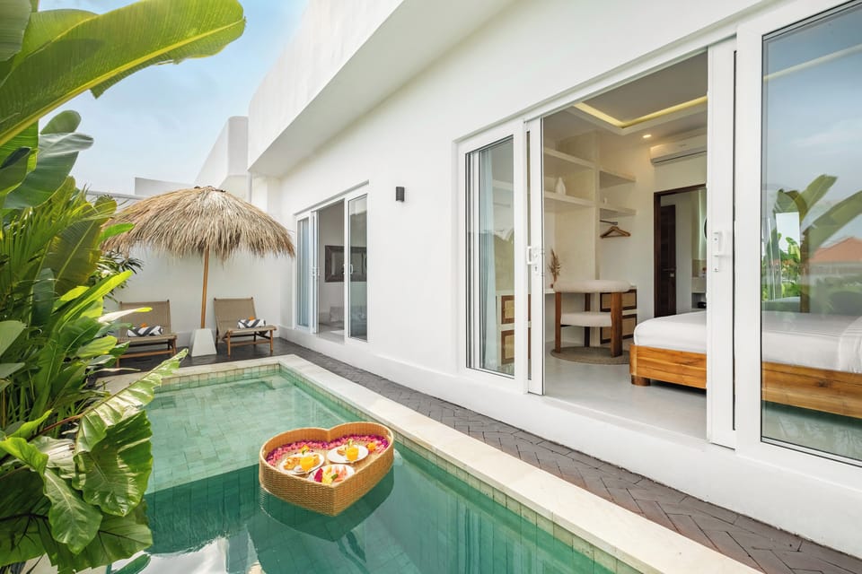 Villa Merlin Canggu – private pool with floatie and sunbeds in tropical garden
