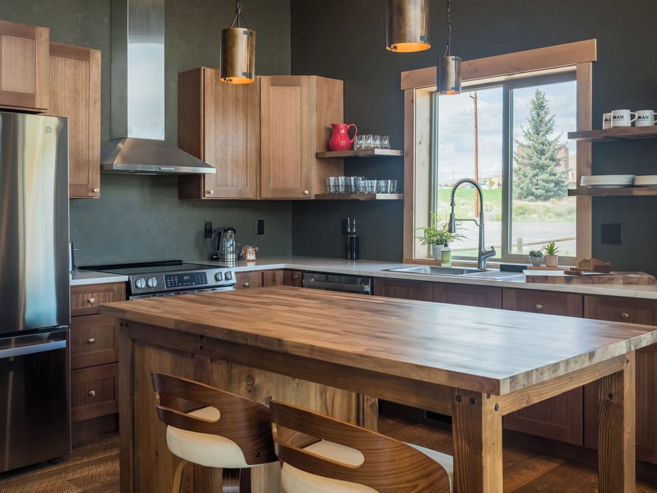 Crafted for Connection and Comfort
This warm, modern kitchen features hand-finished butcher block on the island, sleek quartz countertops, and open shelving for a clean, curated look. Whether you're preparing a family-style dinner or simply unwinding with a drink at the island, this space blends utility with understated elegance.
