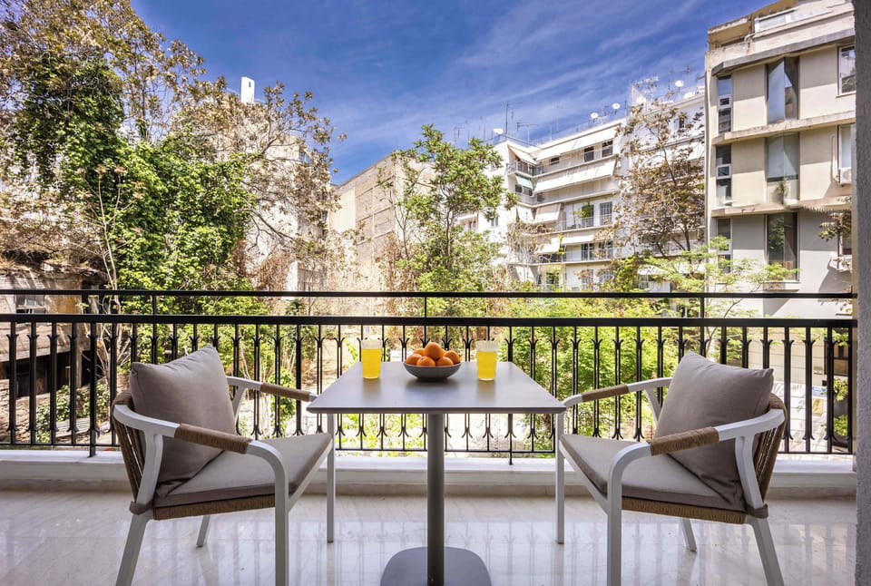 Sunny balcony oasis, perfect for morning juice or evening chats overlooking charming Athens courtyard