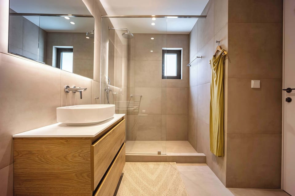 Stylish bathroom escape, warm lighting, spacious shower, and refined finishes elevate everyday routines.

