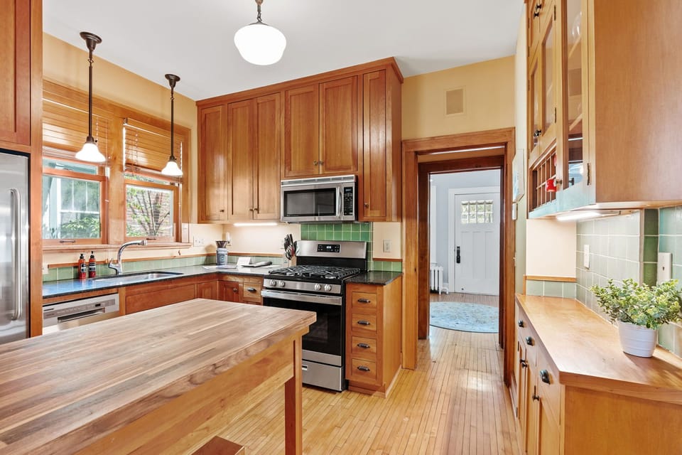 Gather in your well-appointed kitchen featuring rich wood cabinetry, granite counters, and modern appliances perfect for preparing memorable meals together.
