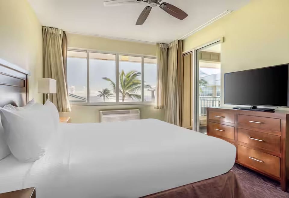 Wake to palm-framed views and soft light in bed.