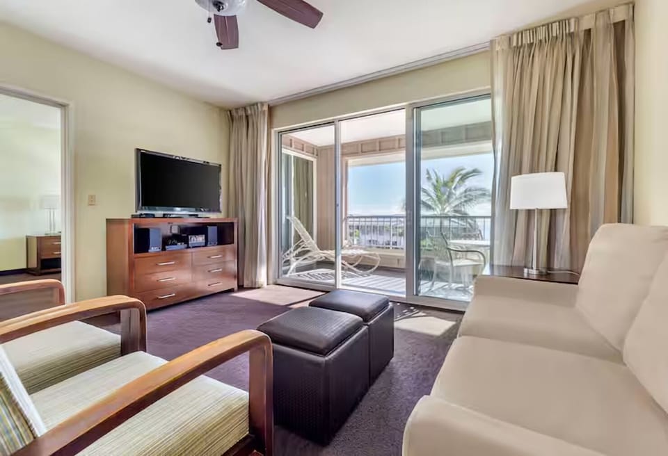 Unwind in a sunlit lounge with breezy balcony views.